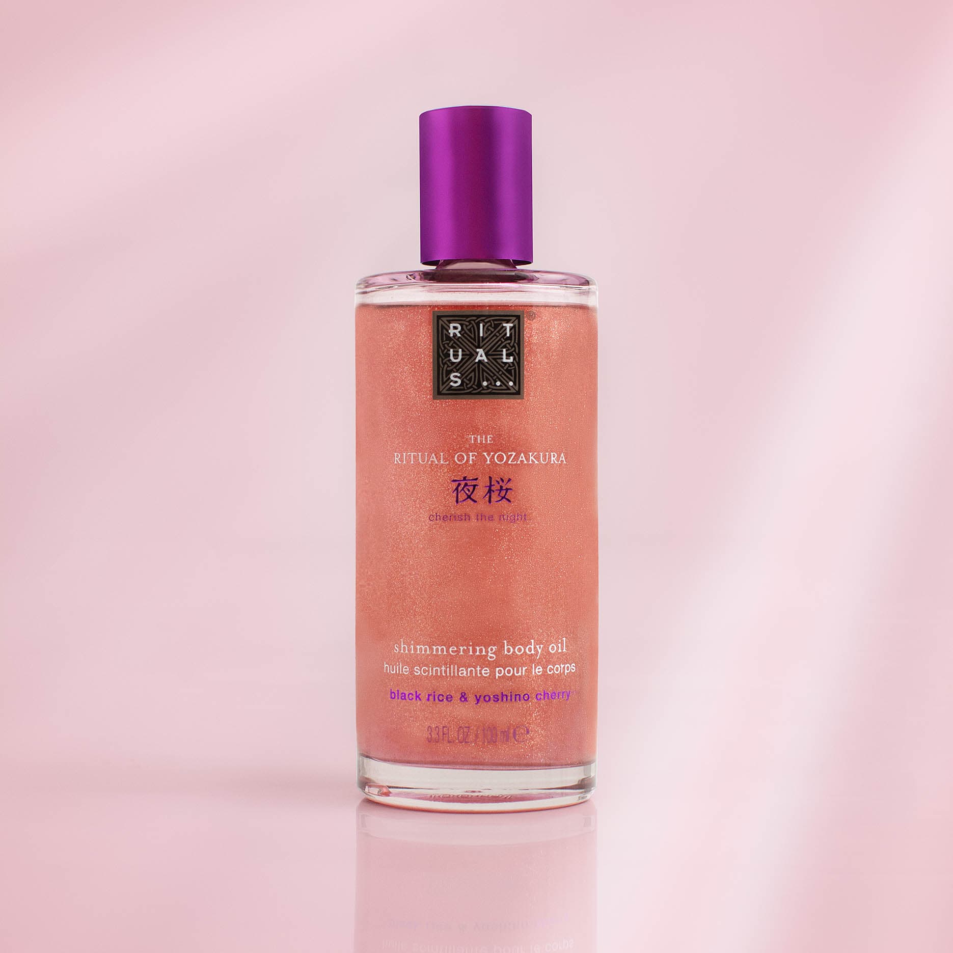 Rituals shimmering body oil on a softly lit pink background