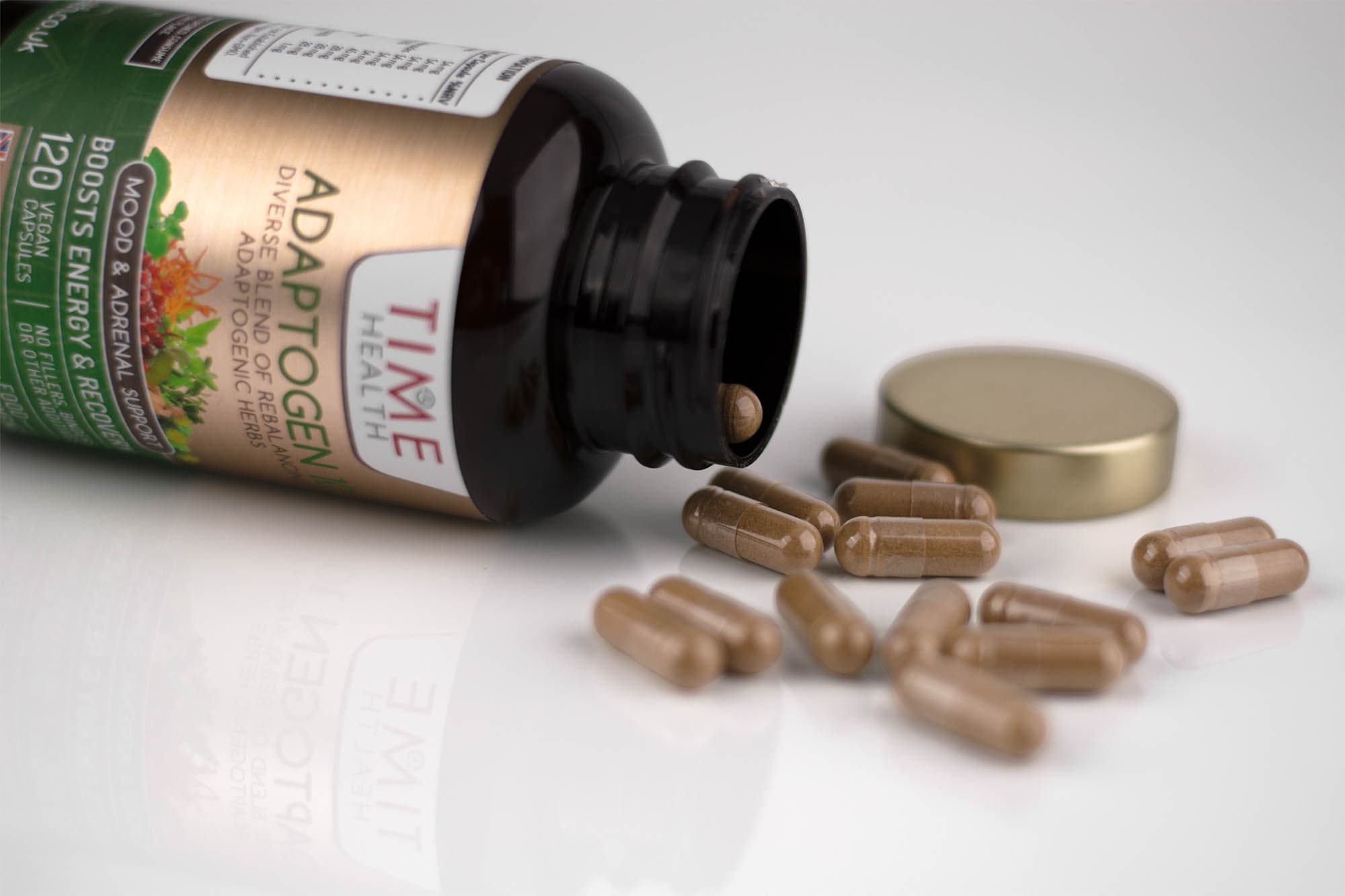 Supplement bottle on its side with capsules on a pale surface