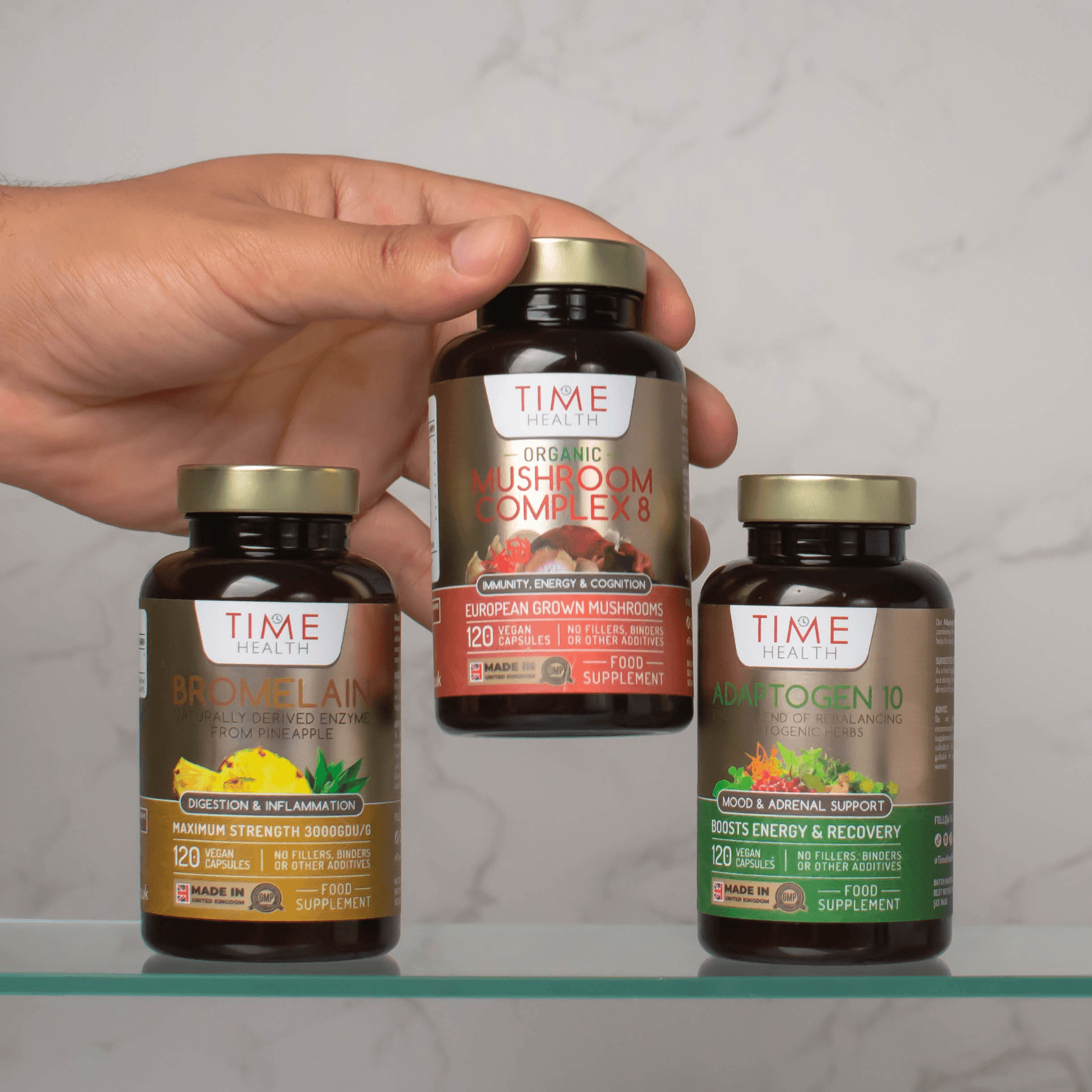 Hands arranging a group of supplement bottles against a muted background