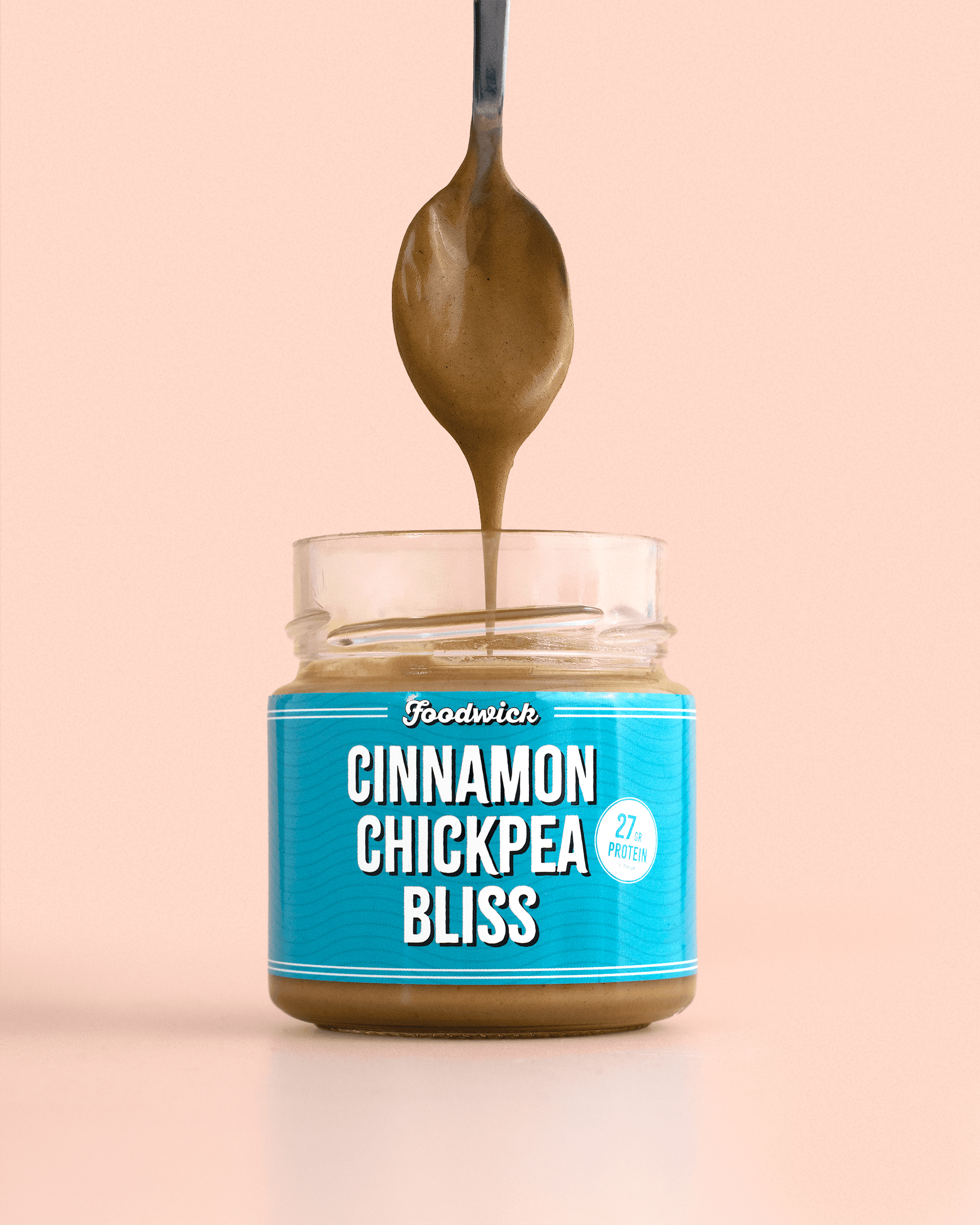 Cinnamon chickpea spread flowing from a spoon into a jar