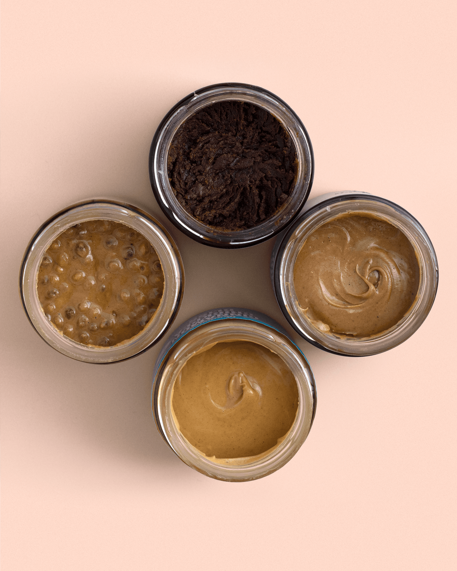 Flat lay of four open spread jars showing different textures