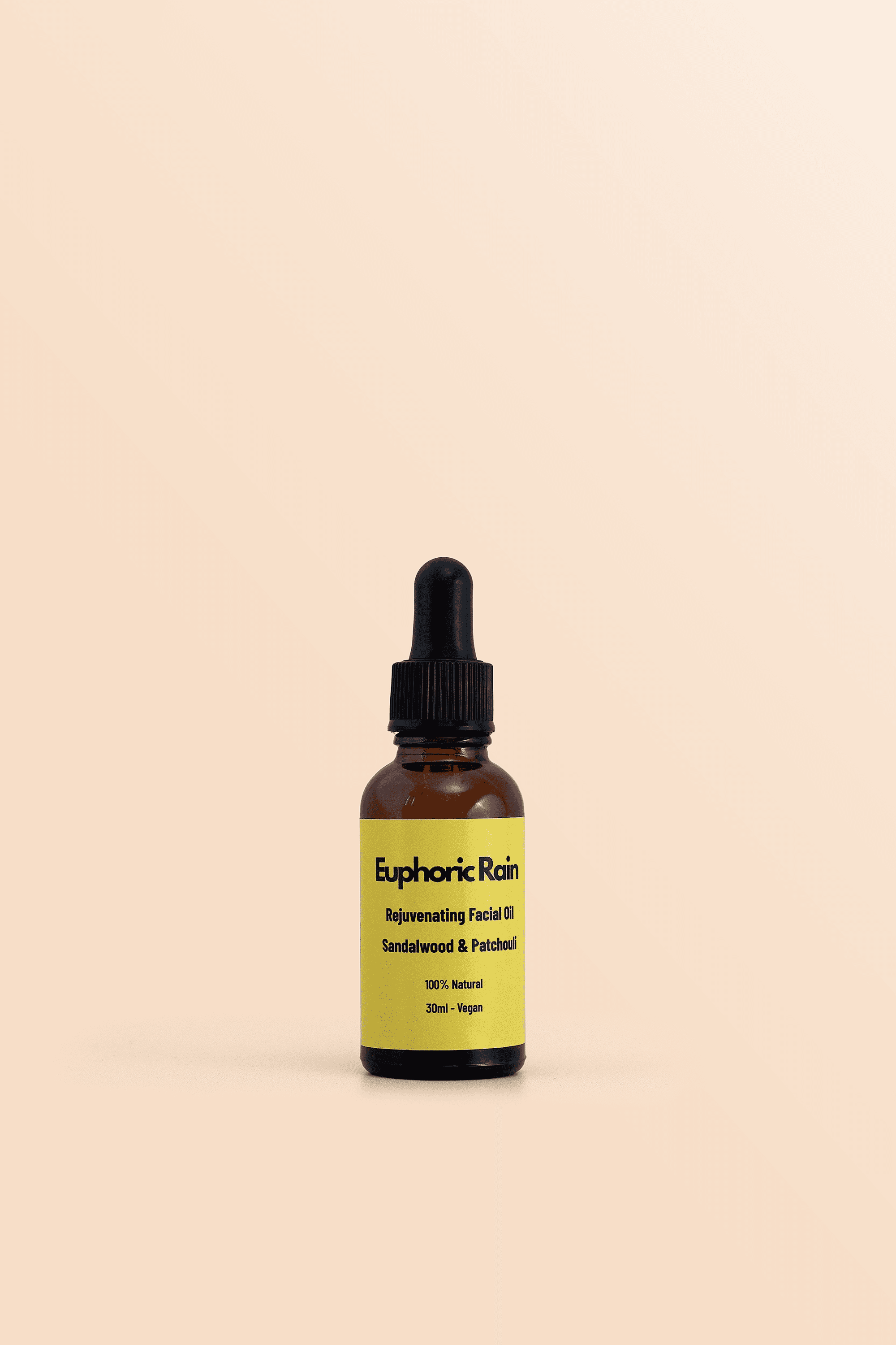 Amber skincare dropper bottle with a yellow label on peach