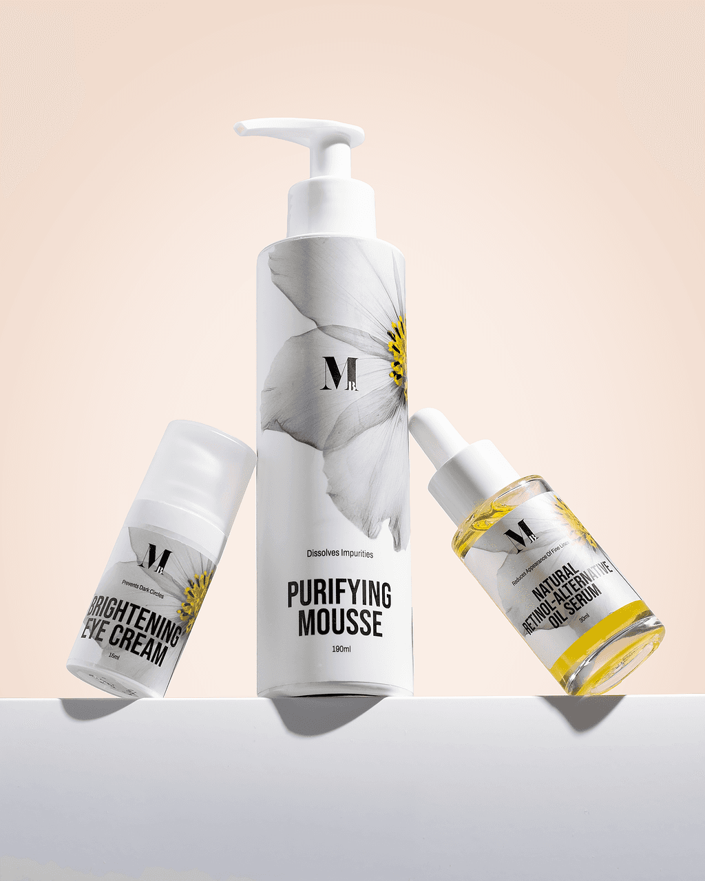 Three white skincare bottles arranged around a central mousse bottle
