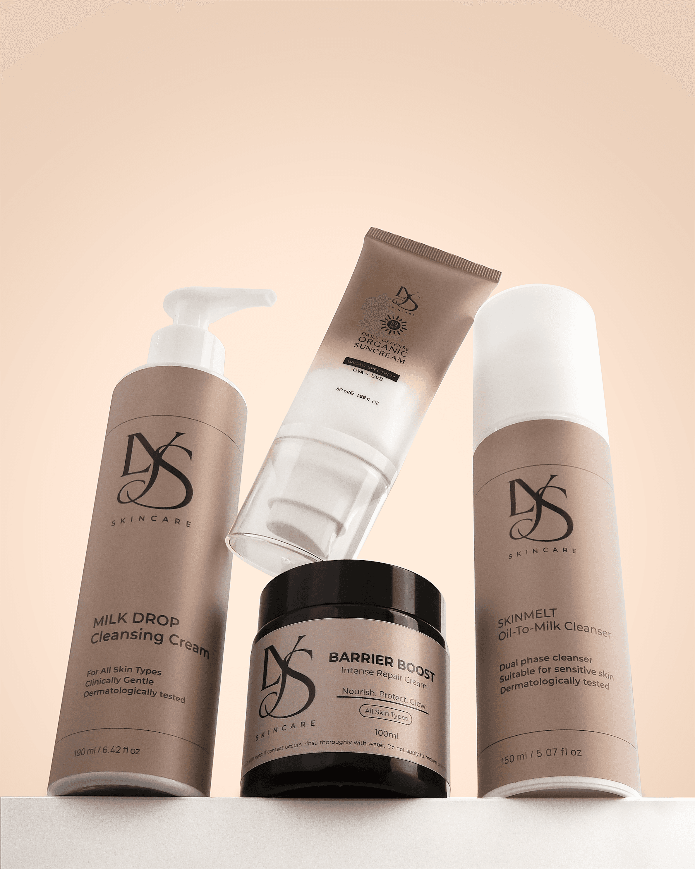 A collection of neutral cosmetic tubes, bottles and jars on peach